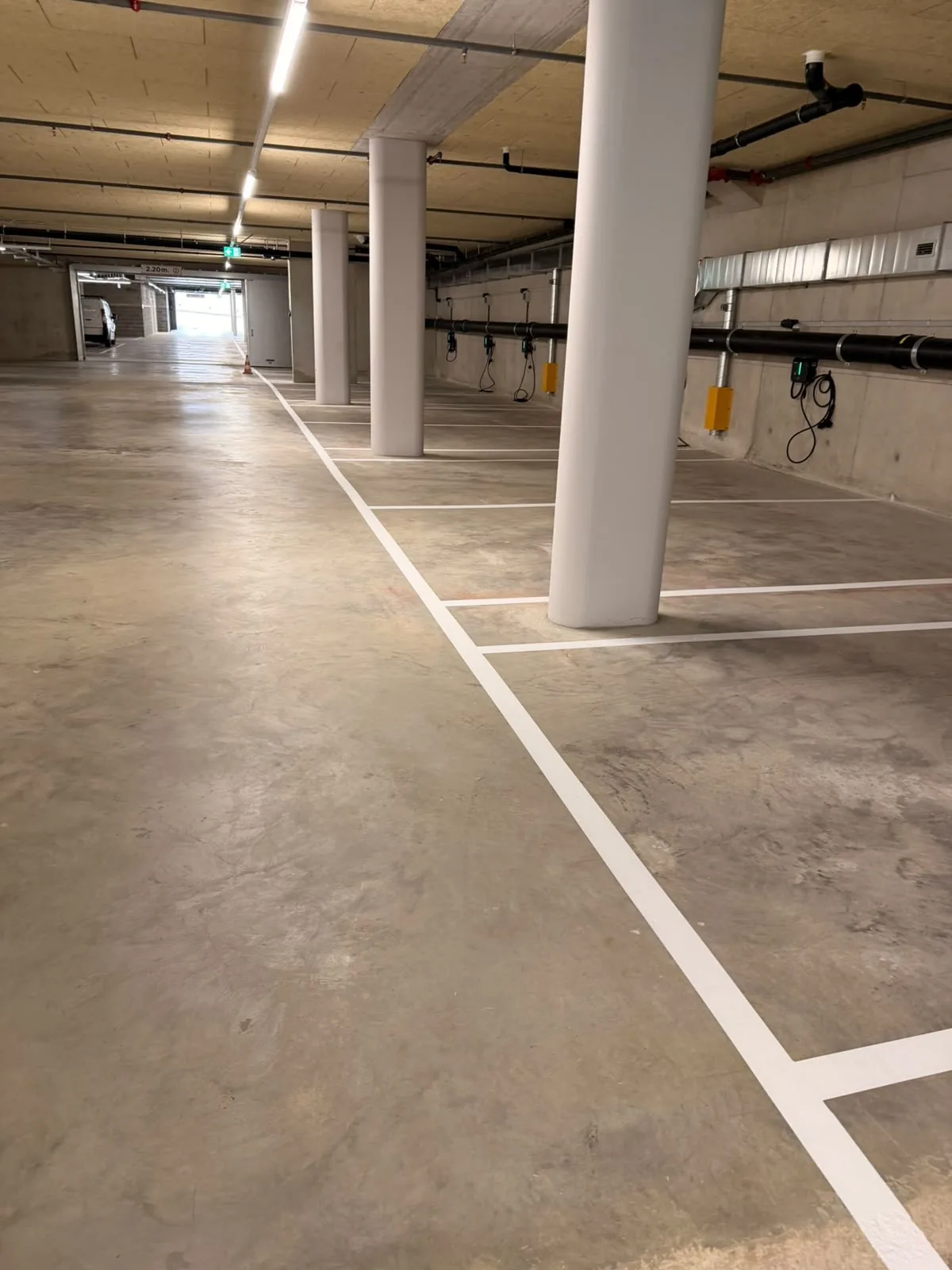 Cases de stationnement marquées en blanc dans un parking souterrain