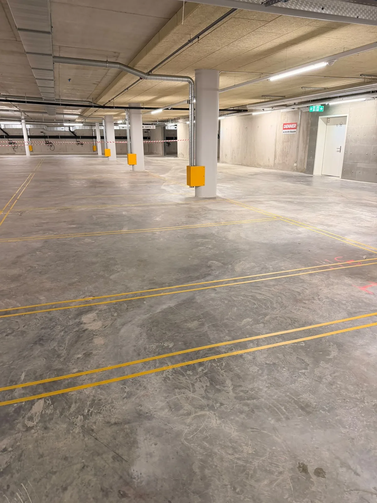 Lignes jaunes fraîchement tracées dans un parking couvert