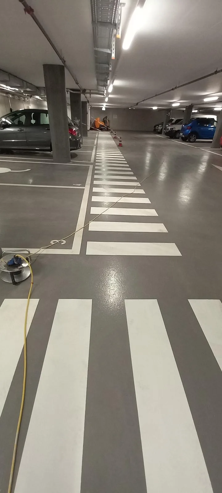 Marquage de passage piéton gris et blanc en parking