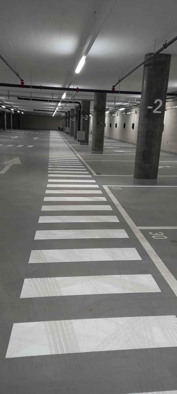 Passage piéton blanc dans un parking souterrain éclairé