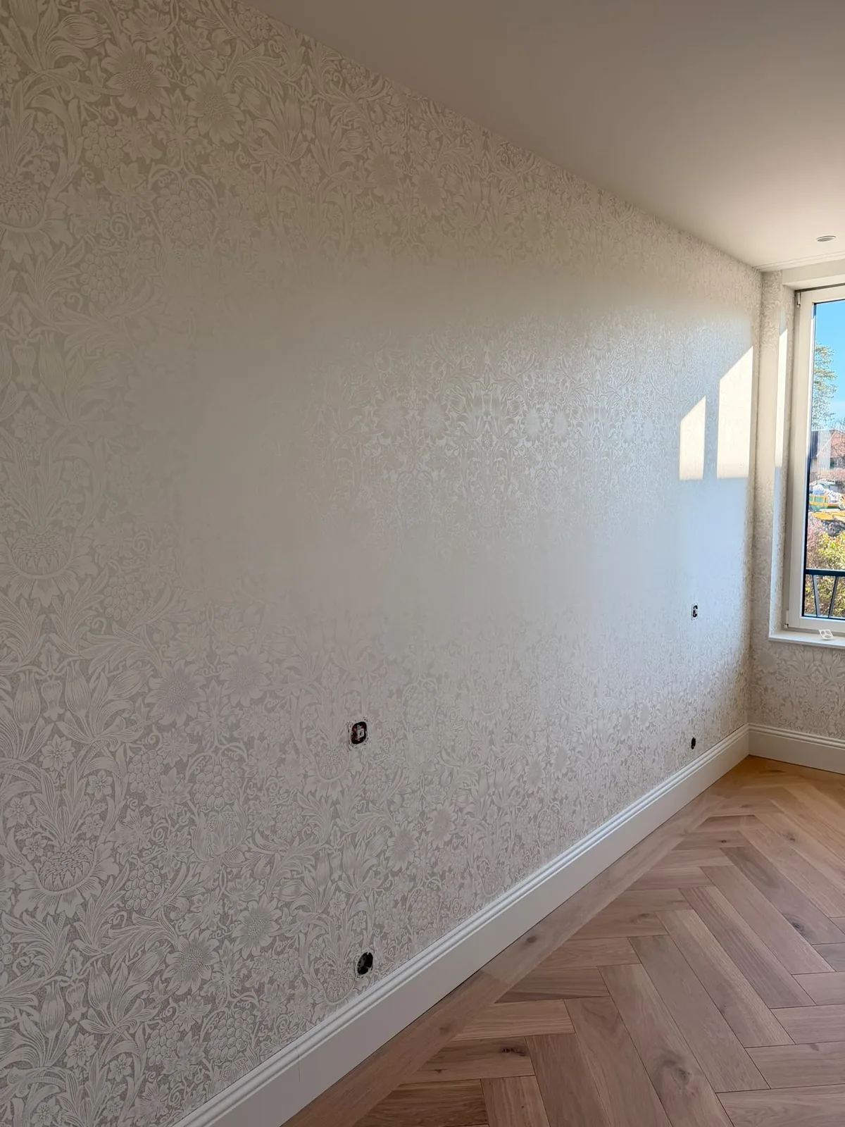 Papier peint texturé clair dans une chambre au parquet chevrons