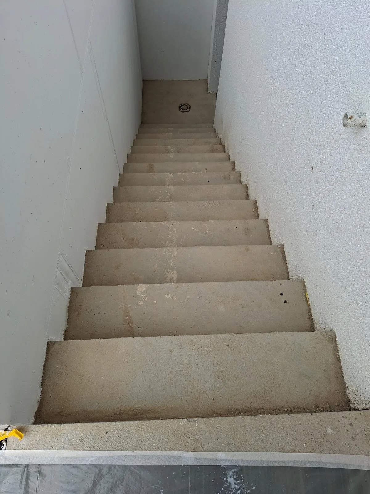 Cage d'escalier repeinte en blanc, marches en pierre naturelle