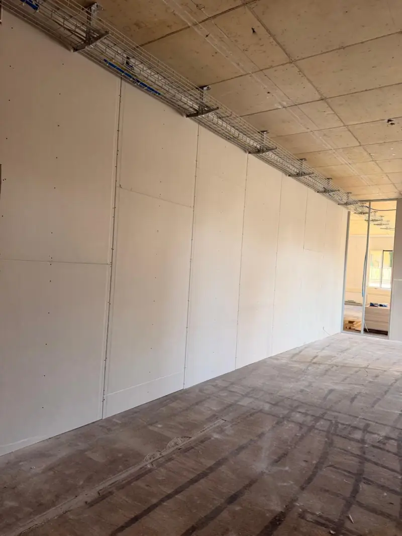 Cloison en plaques de plâtre posée le long d’un plateau de bureaux