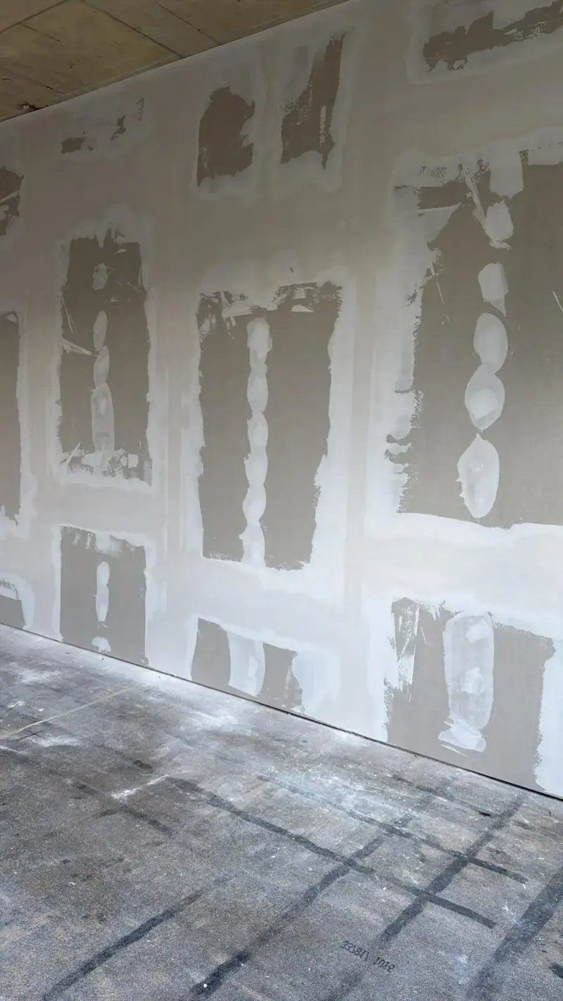 Grand mur en plaques avec joints et têtes de vis enduits