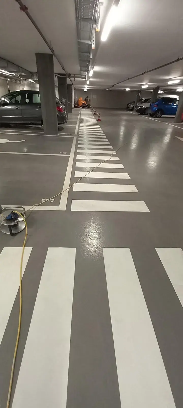Marquage de passage piéton gris et blanc en parking