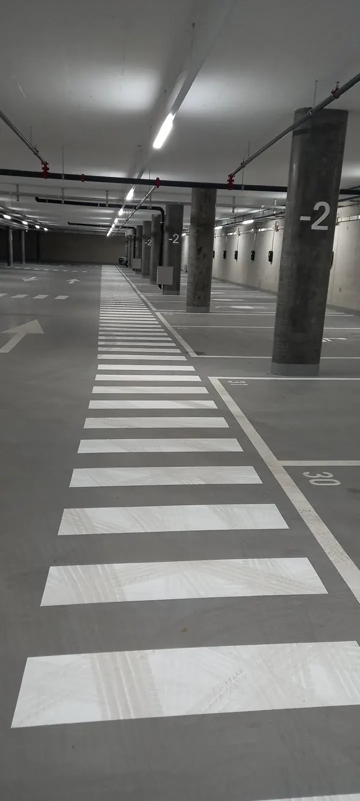 Passage piéton blanc dans un parking souterrain éclairé