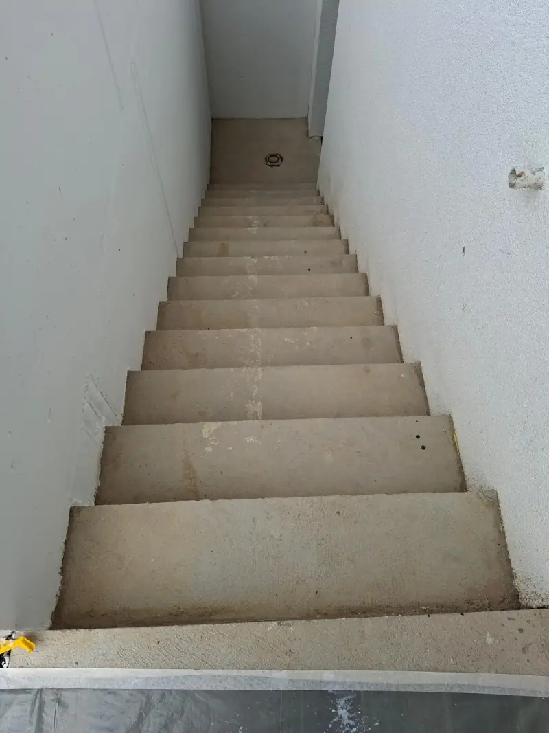 Cage d’escalier repeinte en blanc, marches en pierre naturelle