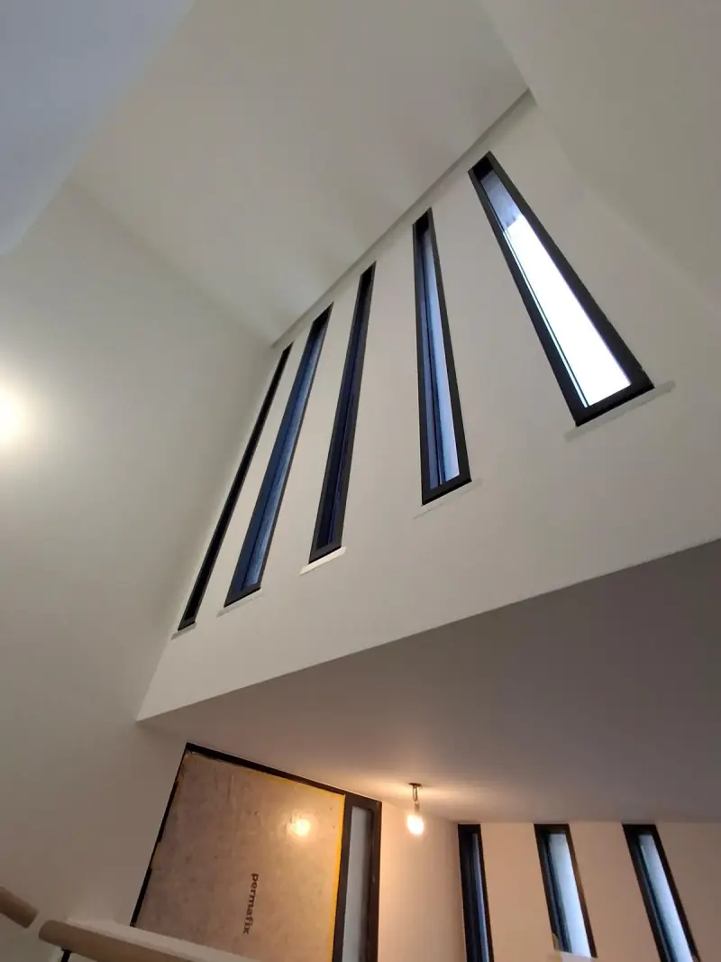 Plafond cathédrale blanc avec fentes vitrées verticales