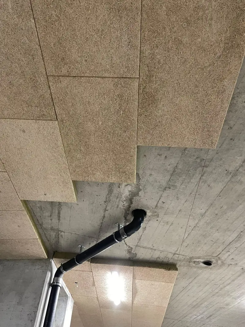 Panneaux de fibre isolante fixés sous une dalle de parking